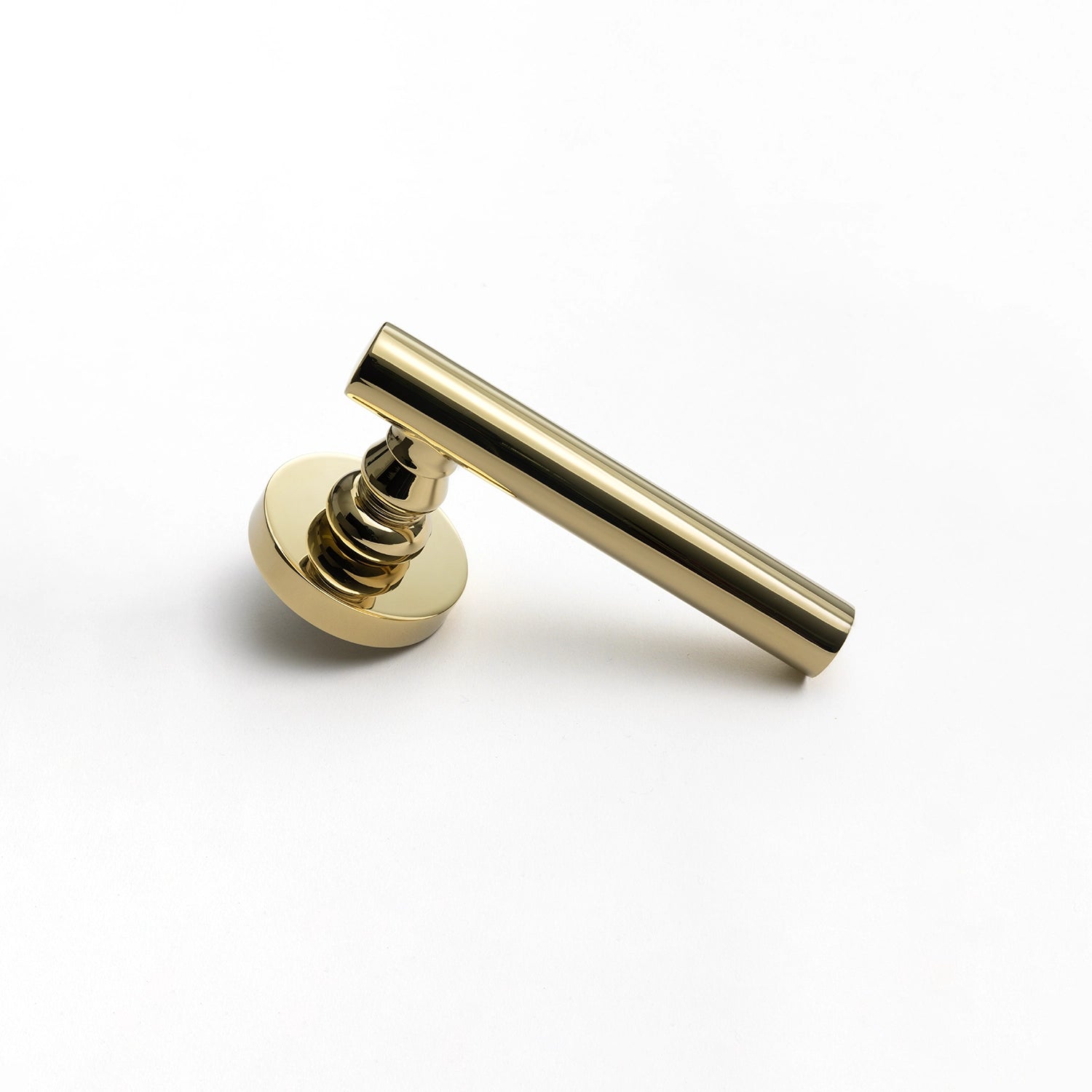 Alda polished brass internal door handle with a round rose, sleek design, positioned vertically standing on its base.