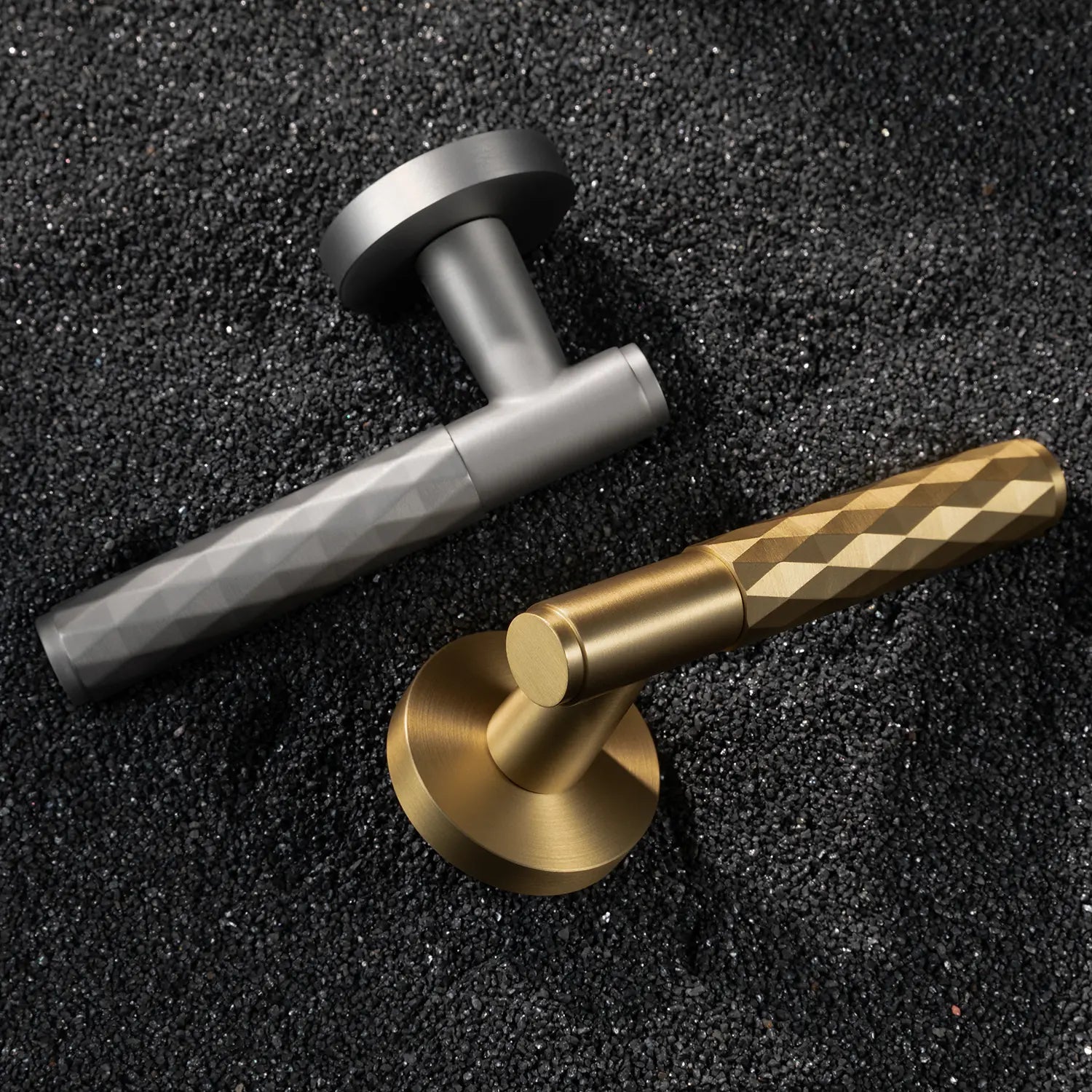 Two Fendal-01 door handles in satin brass and nickel finishes with diamond pattern grips, displayed on a textured stone background.