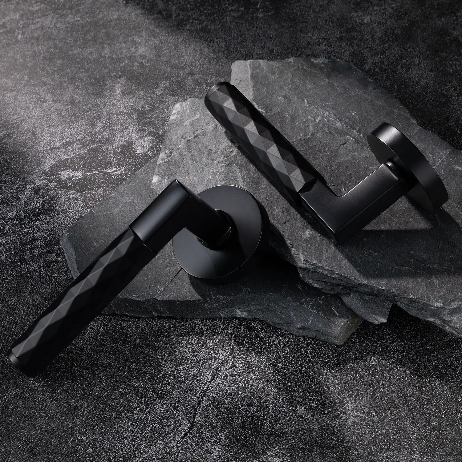 Two Fendal-02 internal black door handles with diamond pattern grip, showcased on a textured stone background.