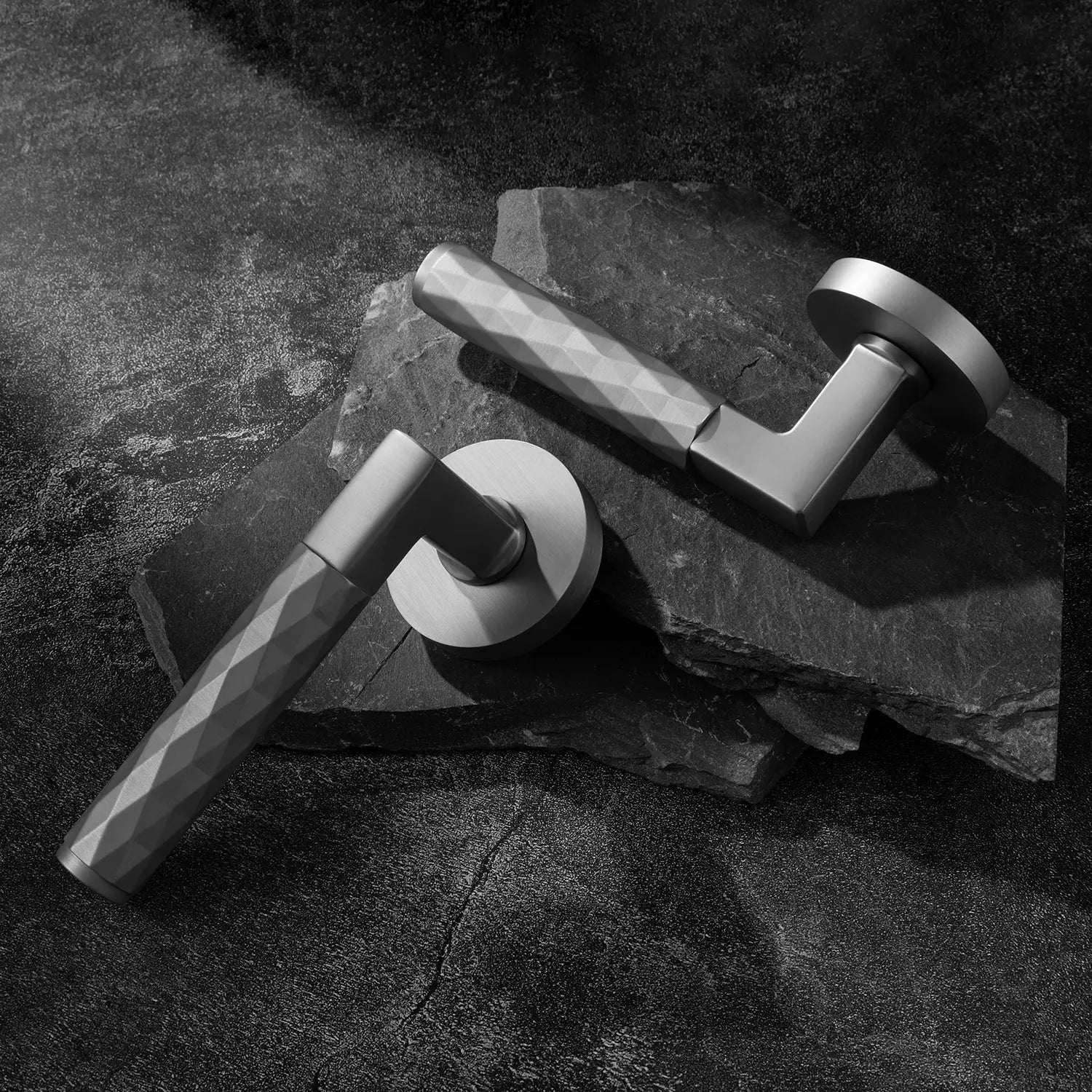 Two Fendal-02 nickel internal door handles with diamond pattern grip, showcased on a textured stone background.