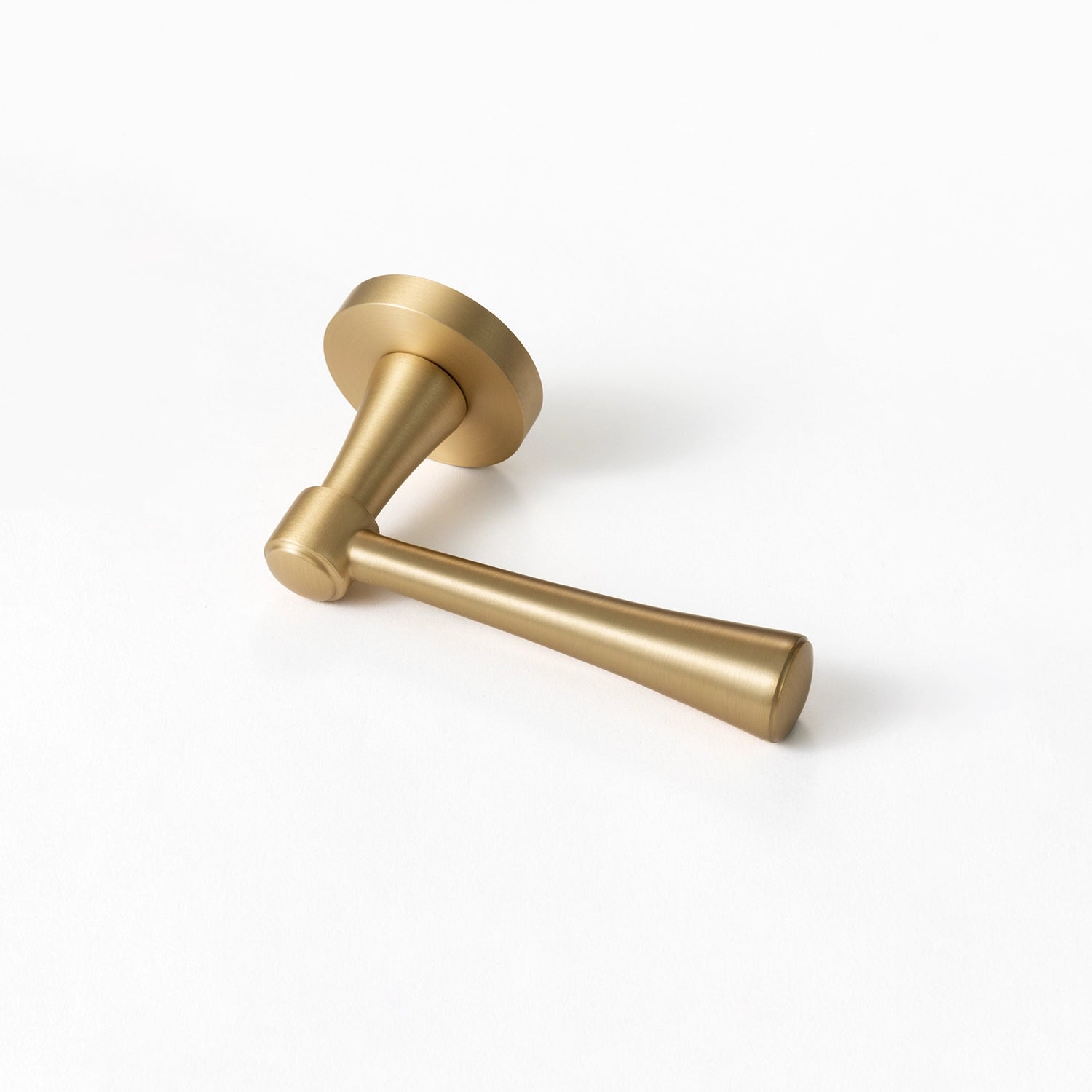 Hilda door handle in satin brass finish, positioned horizontally on a flat surface, showcasing streamlined cone design.