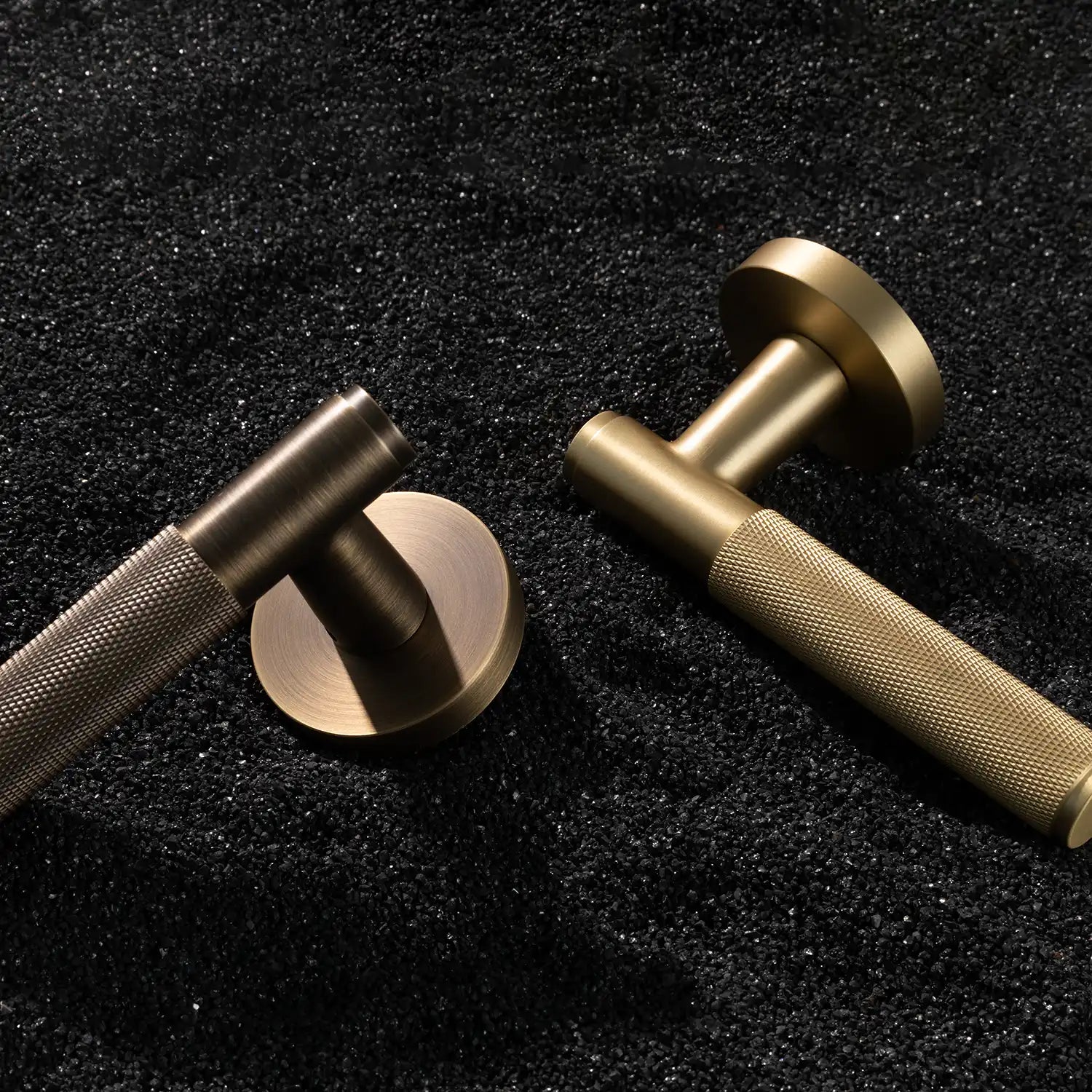 Two Svik-01 internal door handles with knurled pattern in antique brass and satin brass finishes, displayed on a textured gravel background.