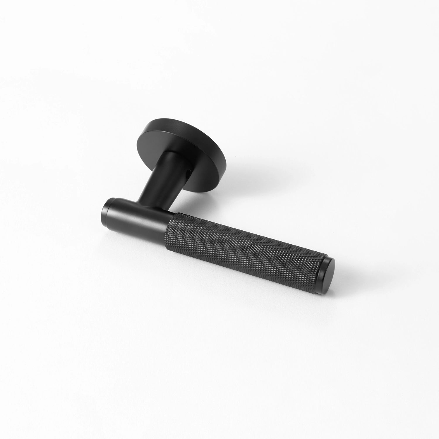 Svik-01 door handle in black finish, featuring an extended knurled pattern grip for a modern industrial aesthetic. Positioned horizontally on a plain white background to highlight its intricate texture.