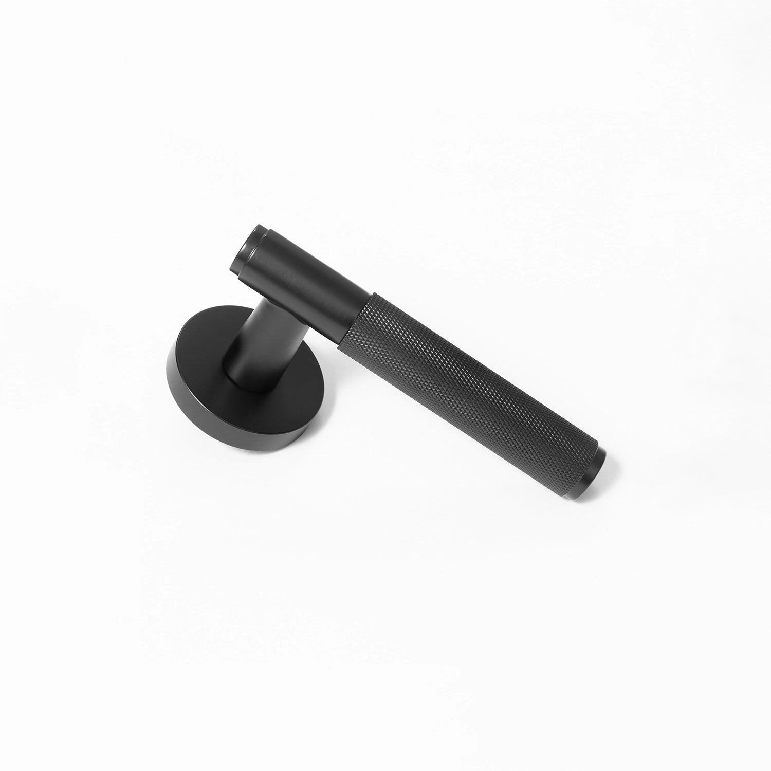 Svik-01 black door handle with knurled pattern, standing vertically on a flat surface, showcasing its industrial aesthetic.