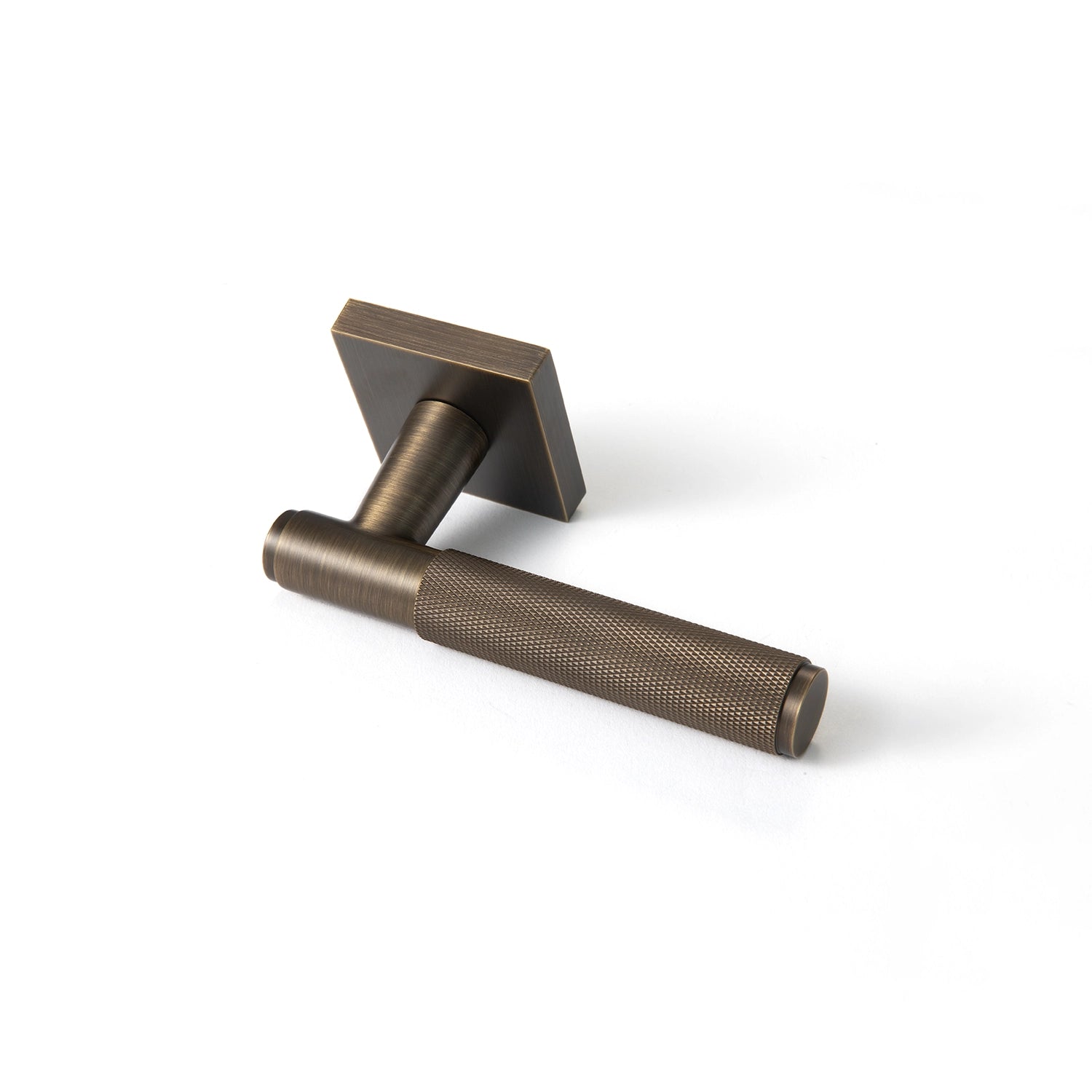 Svik-01 internal door handle in antique brass finish with knurled pattern grip, positioned horizontally with square rose base.