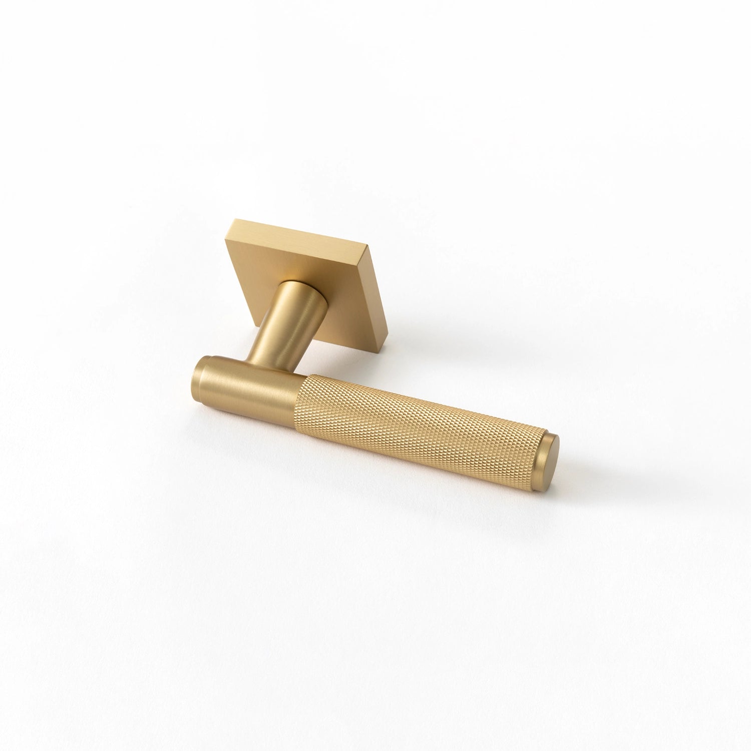 Svik-01 internal door handle in satin brass finish with knurled pattern grip, positioned horizontally with square rose base.