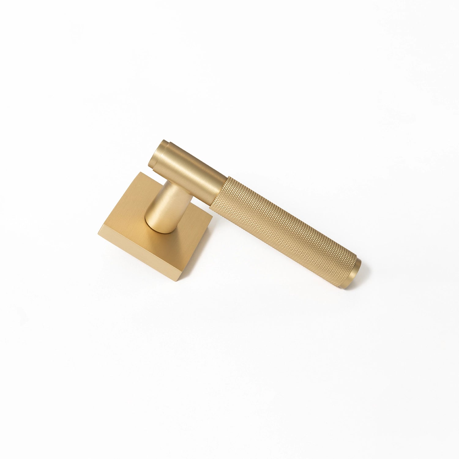 Svik-01 internal door handle in satin brass finish with knurled pattern grip, standing upright on a square rose base.