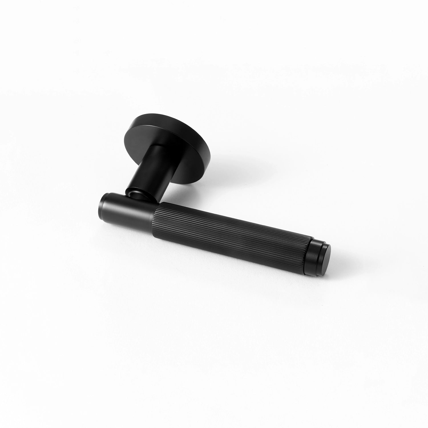 Svik-02 internal door handle in black finish, positioned horizontally on a flat surface, showcasing a linear pattern on the gripping section.