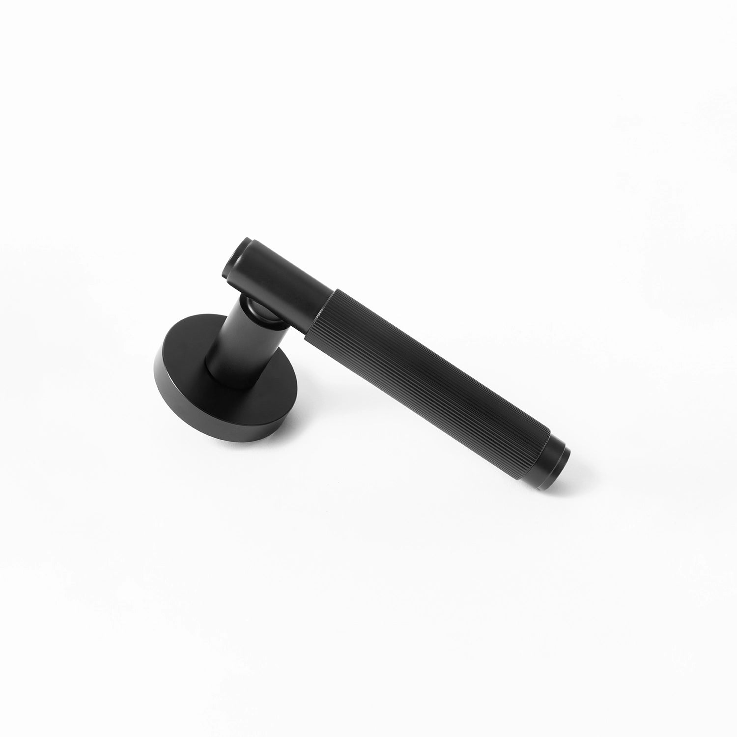 Svik-02 internal door handle in black finish, lying diagonally with a round rose base, featuring a distinct linear pattern on the handle.