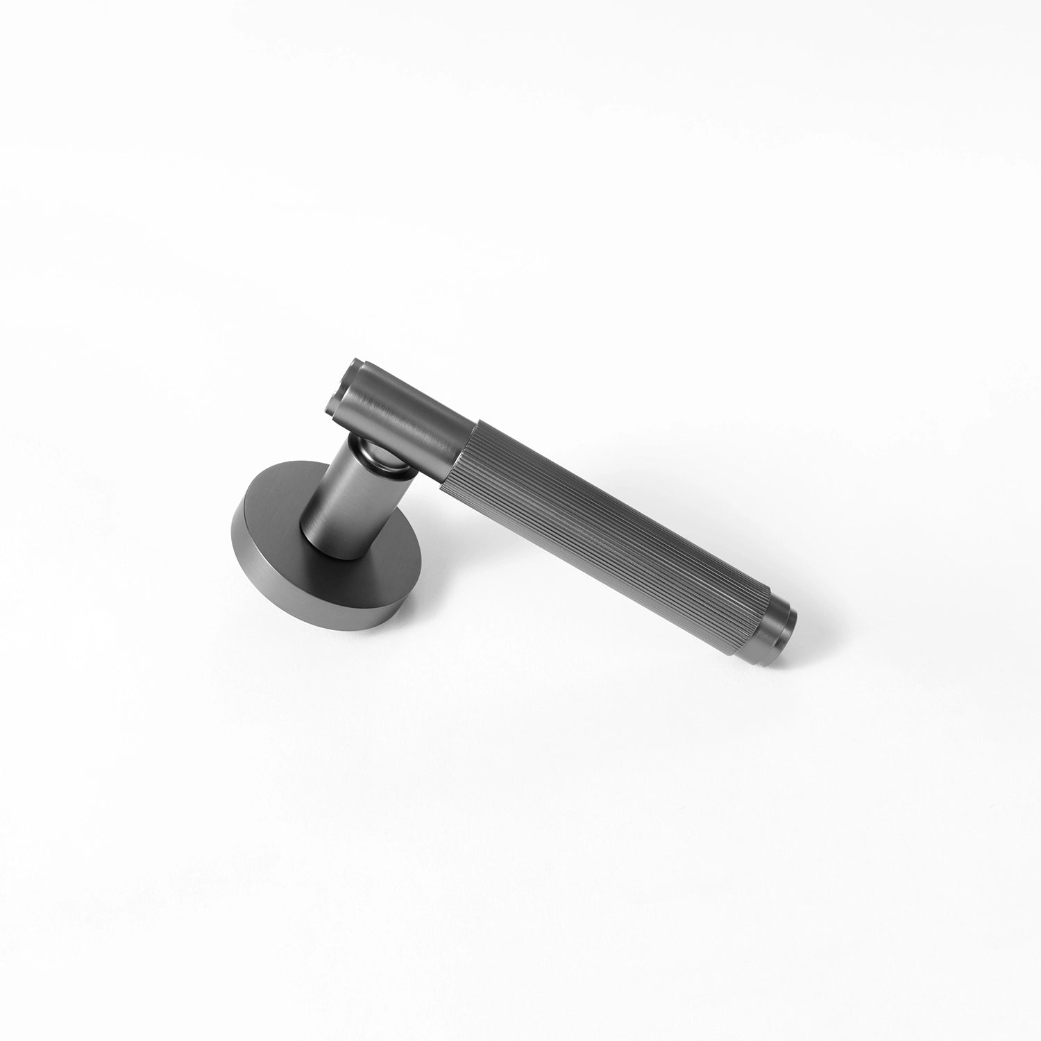 Svik-02 internal door handle in charcoal grey finish, lying diagonally with a round rose base, featuring a distinct linear pattern on the handle.