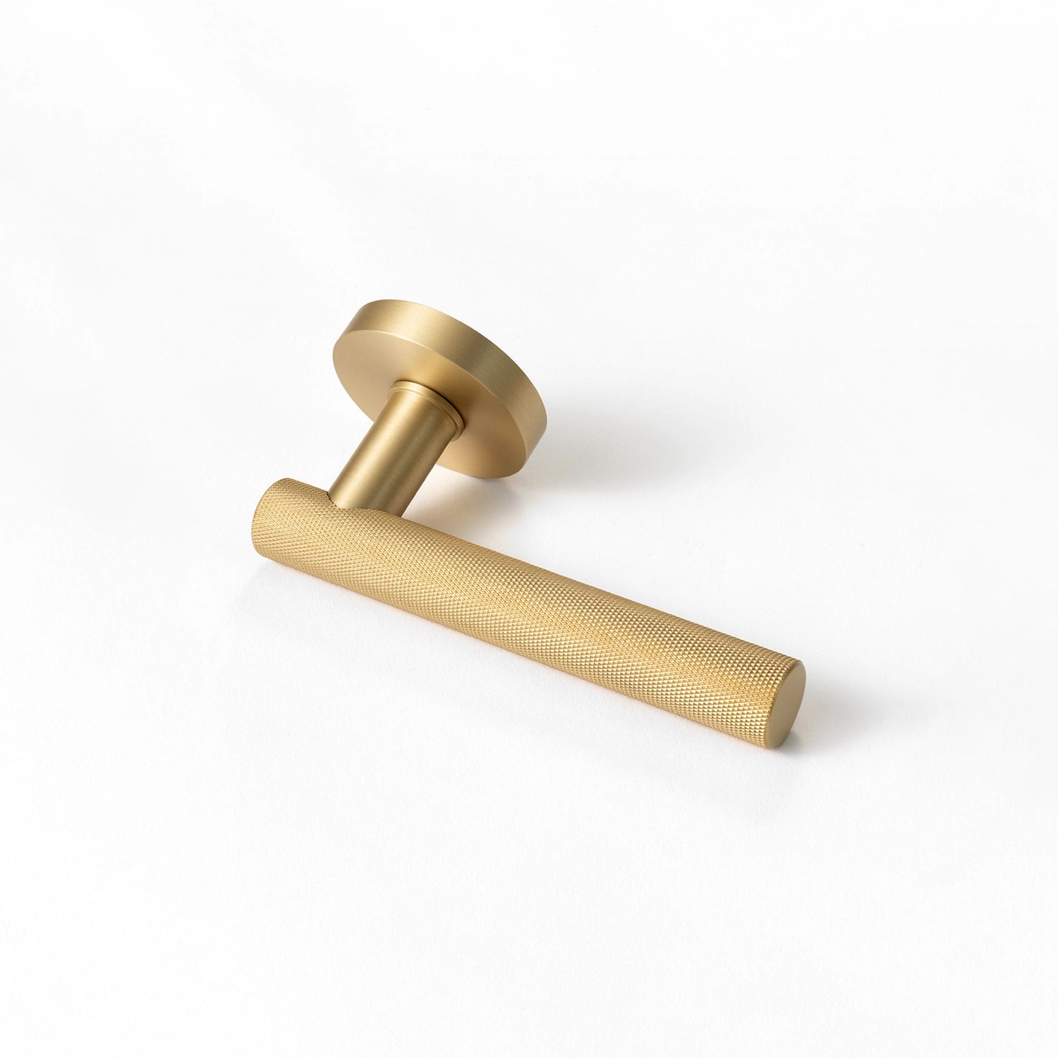 Tord-01 internal door handle in satin brass finish, featuring a fully knurled pattern covering the entire handle, positioned horizontally on a white background.