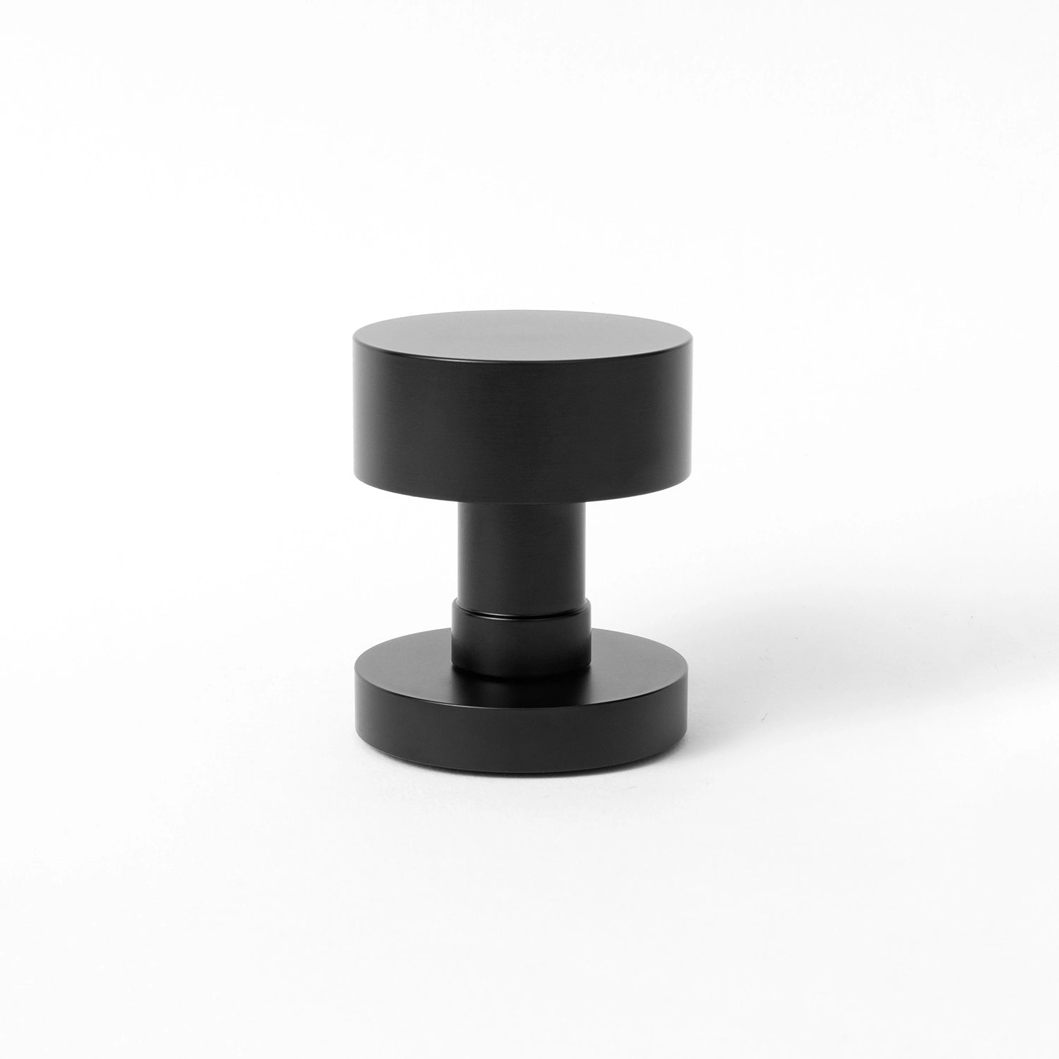 Solda door knob in black finish, showcased upright on a white background, highlighting its cylindrical and modern design.