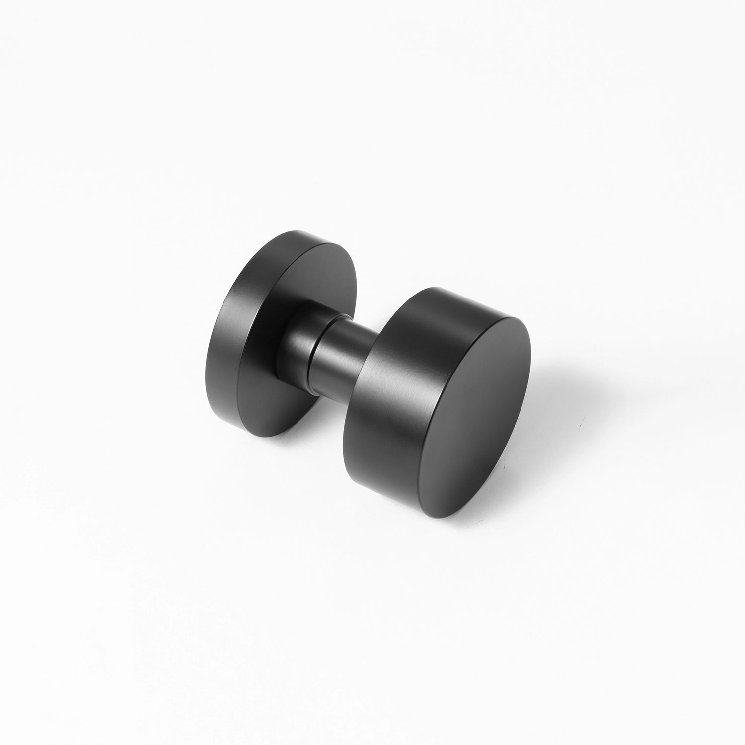Solda round door knob in black finish, positioned at an angle on a white background, showcasing its minimalist and modern design.