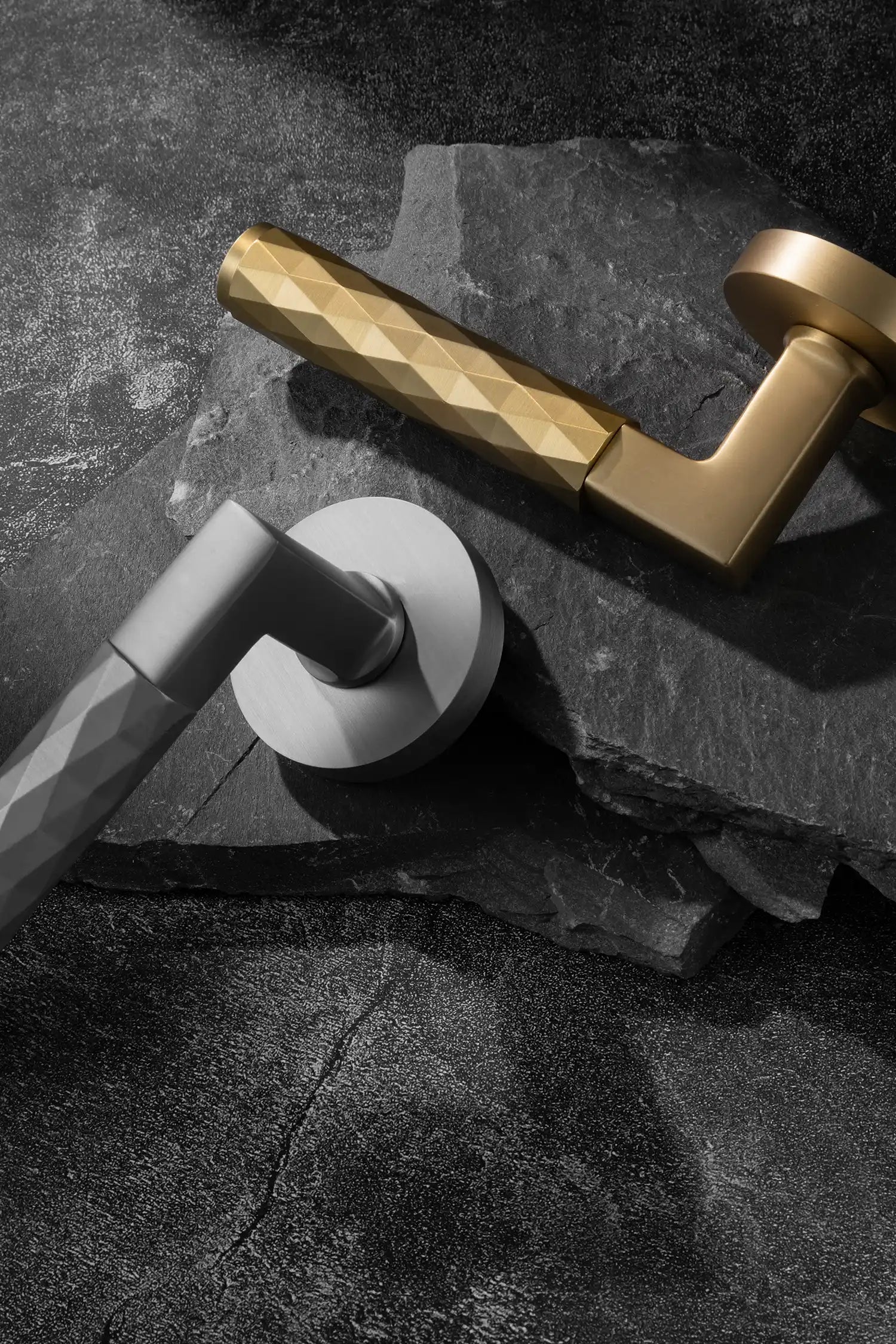 Fendal02 door handles in satin brass and nickel finishes with diamond pattern grips, displayed on a textured stone background. A modern and versatile design for contemporary interiors.