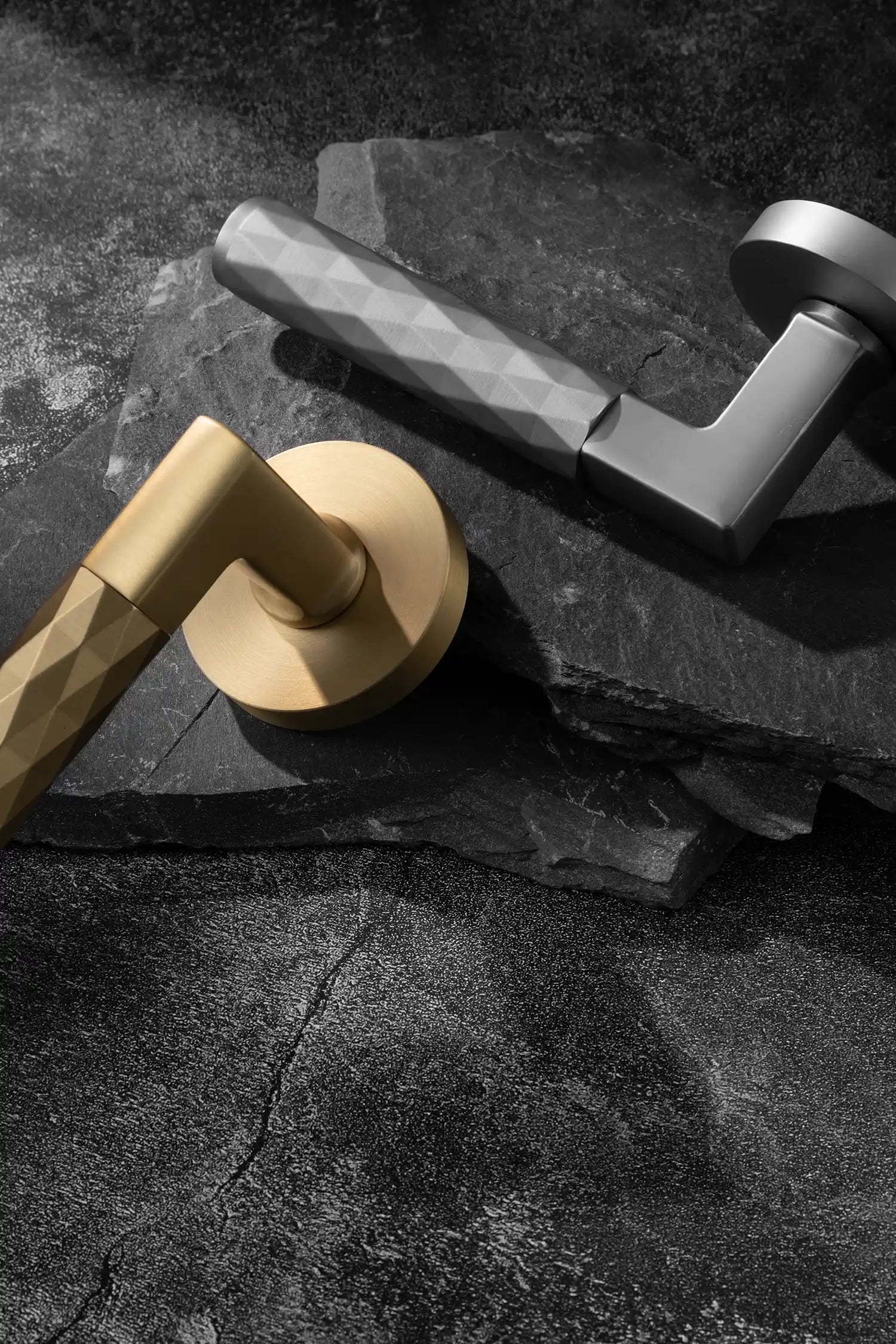 Fendal02 door handles in satin brass and nickel finishes with diamond pattern grips, displayed on a textured stone background. A modern and versatile design for contemporary interiors.